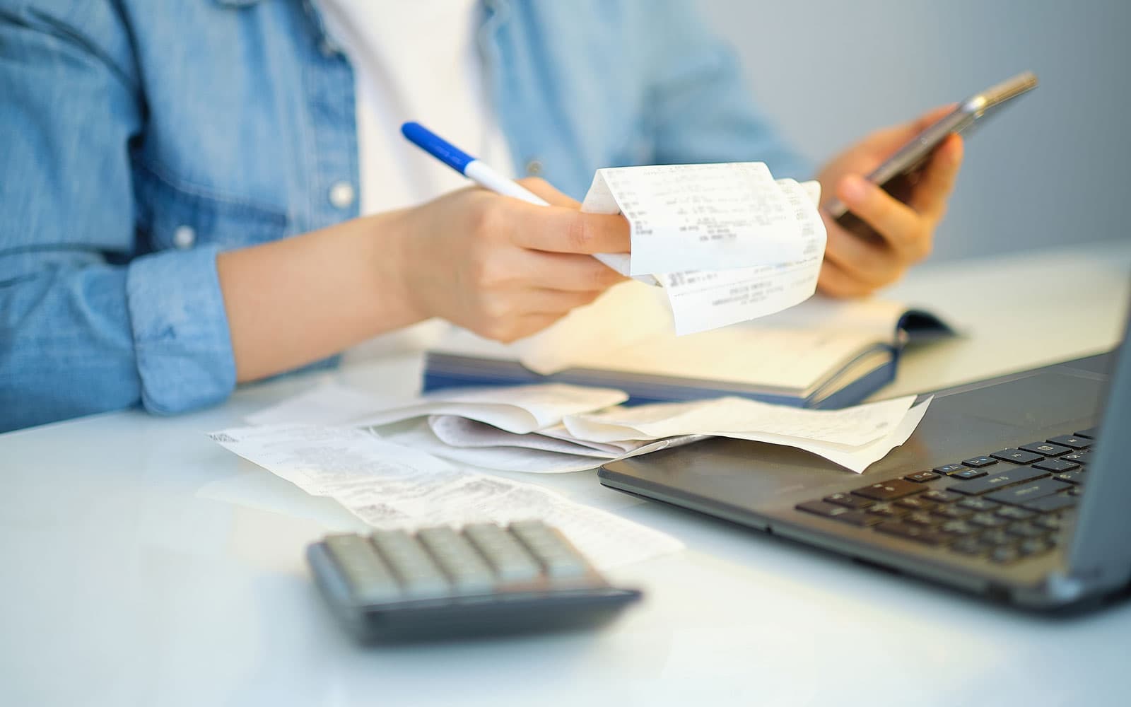 Contract pages, calculator, and notes on a desk